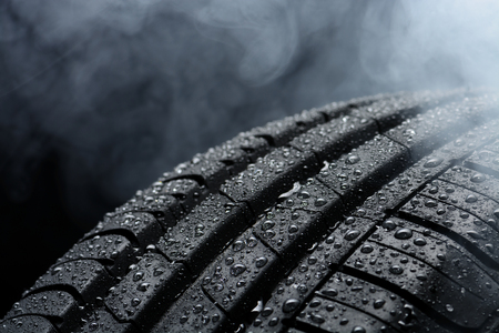 Car tire covered with water drops in the fogの写真素材
