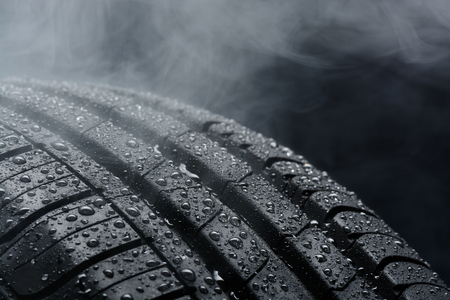 Car tire covered with water drops in the fogの写真素材