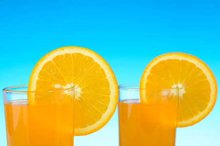 Two glasses of orange juice on the beachの写真素材