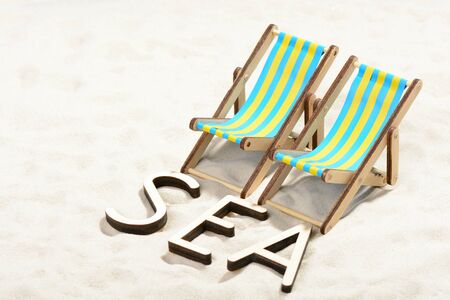 The word SEA and two sunbeds at the beachの写真素材
