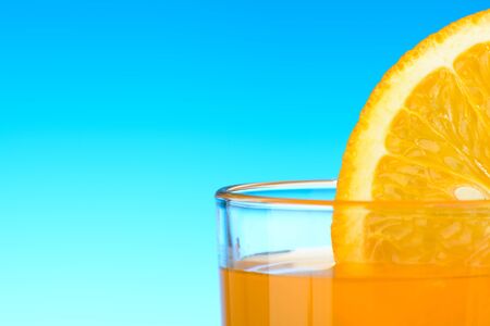 A glass of orange juice on blue backgroundの写真素材