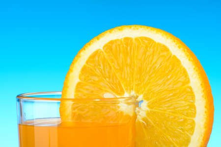 A glass of orange juice on blue backgroundの写真素材