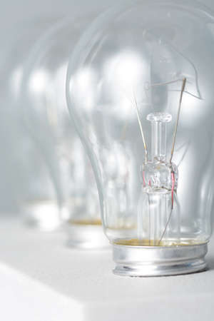 Three incandescent bulbs on grey background