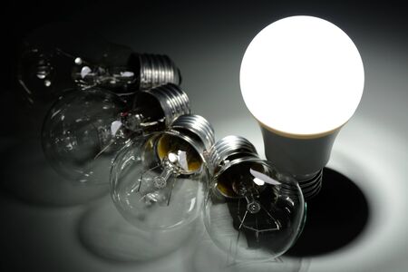 Glowing led lamp and incandescent bulbs in the darkの写真素材