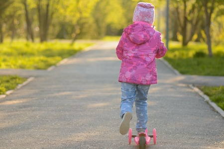 Little girl riding a scooterの写真素材