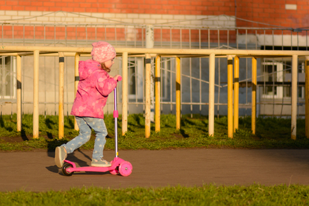 Little girl riding a scooterの写真素材