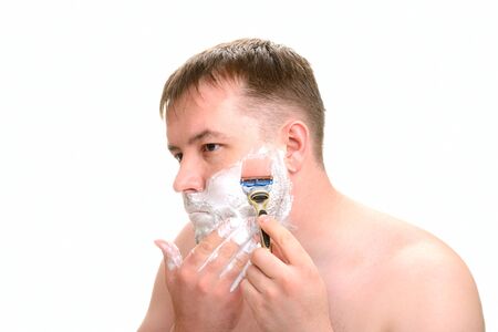 A man shaves on a white backgroundの写真素材
