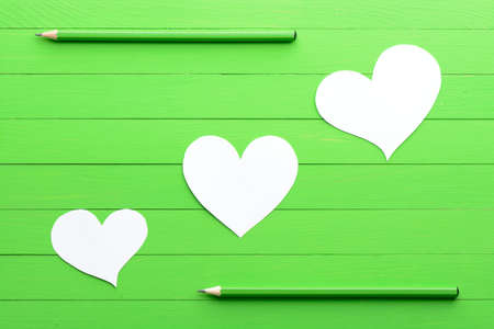 Stickers in shape of heart on green wood backgroundの写真素材