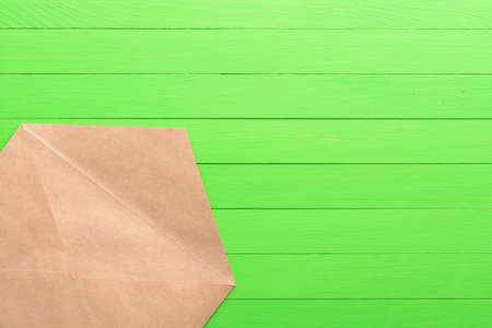 Brown envelope on green wooden backgroundの写真素材