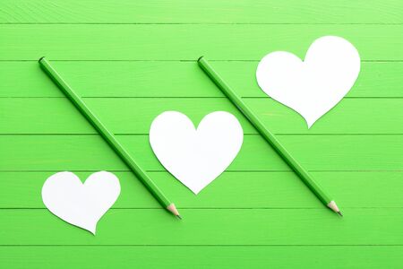 Stickers in shape of heart on green wood backgroundの写真素材