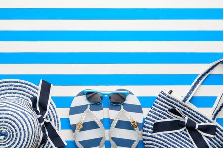 Beach accessories on a blue and white background. Top view, flat lay.
