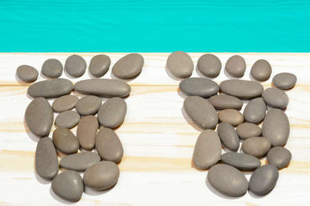 Top view of footsteps made with stones and arranged on wooden surface.の写真素材