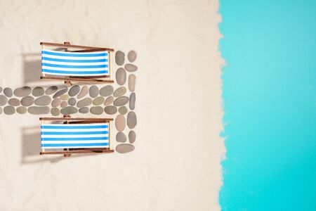 Top view of beach with two chairs and pathway made with pebbles.の写真素材