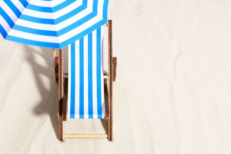 From above of lounge area on beach with striped chair under umbrella.の写真素材