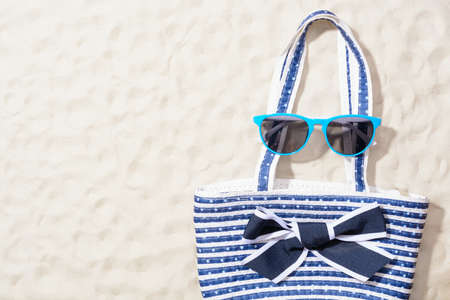 Beach bag with sun glasses on the sand. Top viewの写真素材