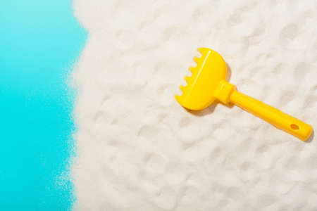 From above shot of yellow plastic rake for sandbox and drawing on sand.の写真素材