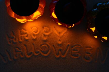 From above shot of congratulations Happy Halloween written on sand near pumpkinsの写真素材