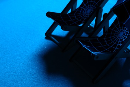 Two beach chairs and umbrellas with web pattern in moonlight on beachの写真素材