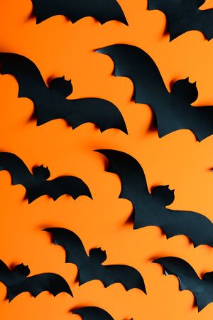 A flock of paper bats on the orange wallの写真素材