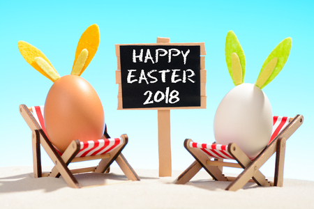 Happy Easter 2018 sign and two eggs on loungersの写真素材