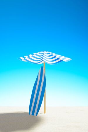 Surfboard under an umbrella on the sandy beach, sky with copy spaceの写真素材