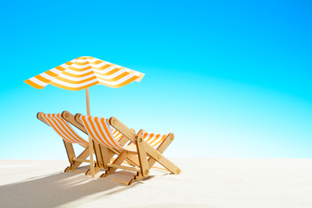 Two chaise longue under an umbrella on the sandy beach, sky with copy spaceの写真素材