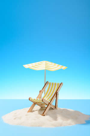 The concept of a tropical vacation. A chaise longue under an umbrella on the sandy island. Sky with copy spaceの写真素材