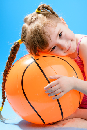 Cute little girl with the big inflatable beach ballの写真素材