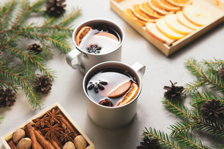 From above metal cups of mulled wine in Christmas tree branches on tableの写真素材