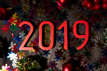 From above of composed bright red number of 2019 New Year on wooden table with glitters and ornamentsの写真素材