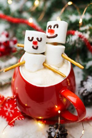 Red mug with hot chocolate and two marshmallows in love. Christmas meeting a couple in love concept.の写真素材