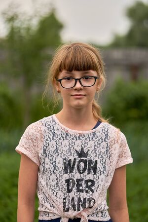 Portrait of a beautiful teenage girl with glasses in the garden.の写真素材
