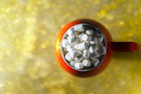 Top view of a red mug with marshmallows on a beautiful blurry background. Christmas composition with sweets.の写真素材