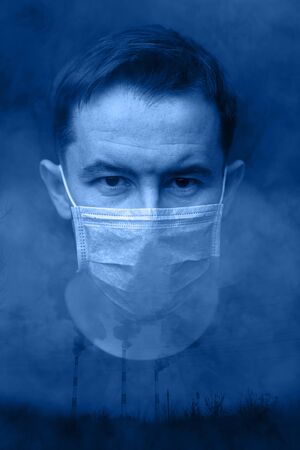 Double exposure of a man in a protective mask and dirty smoke from the exhaust pipes of a production. The concept of air pollution by toxic gases. Toning in the trend color year 2020.の写真素材