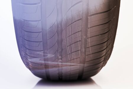 Double exposure of a car tire close-up and suburban asphalt road in the forest. Horizontal orientation.の写真素材