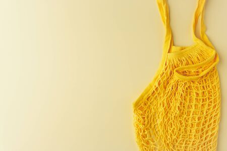 Zero waste concept. Reusable mesh shopping bag on yellow background. Image with copy space, horizontal orientation, top view.の写真素材