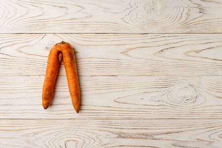 Top view at ugly carrot on a white wooden table. The image contains copy space, horizontal.の写真素材