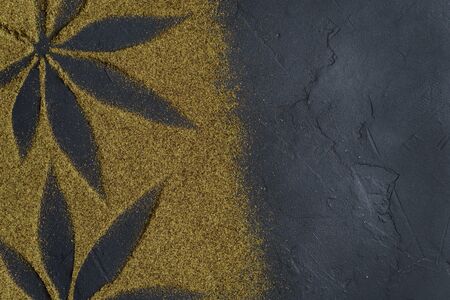 Hemp flour concept, top view. Scattered hemp flour on a dark concrete surface. The image contains copy space, the shape of hemp leaves made of flour, horizontal orientation.の写真素材