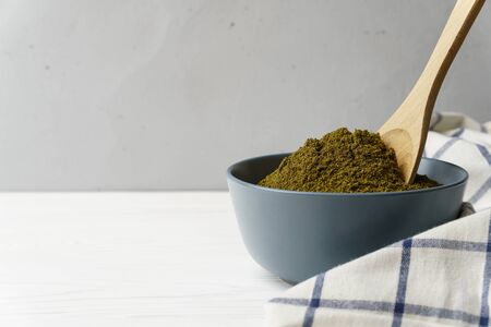Flour hemp in a gray ceramic bowl with a wooden spoon, cellular textiles on a light concrete surface. Image contains copy space.の写真素材