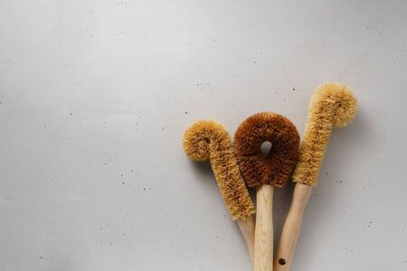 Three dishwashing brushes made from coconut flakes with a bamboo handle. Biodegradable kitchen accessories. Zero waste and no plastic concept. Top view with copy space.の写真素材