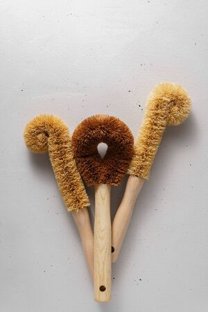 Three dishwashing brushes made from coconut flakes with a bamboo handle. Biodegradable kitchen accessories. Zero waste and no plastic concept. Top view.の写真素材