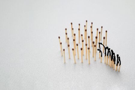 Burnt and whole matches on a gray background. The concept of the importance of social distance. Stop coronavirus pandemic. Copy space, horizontal orientation.の写真素材