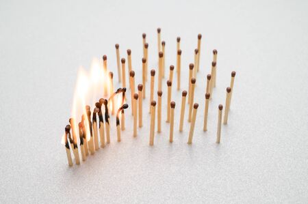 Burning and whole matches on a gray background. The concept of stopping the spread of coronavirus. Keep social distance. Stop 2019-nCov.の写真素材