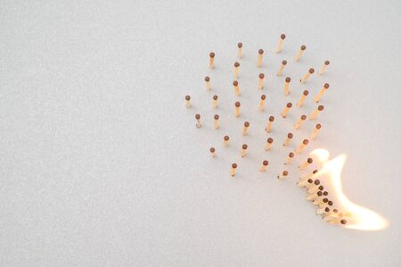 Burning and whole matches on a gray background. The concept of stopping the spread of coronavirus. Keep social distance. Stop COVID-19. Copy space, Top view.の写真素材