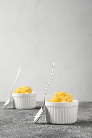 National food cuisine of the Middle East. Sweet dessert made of dough and honey chuck-chuck in white ceramic bowls and two teaspoons on a gray concrete table. Vertical orientation, copy space.の写真素材