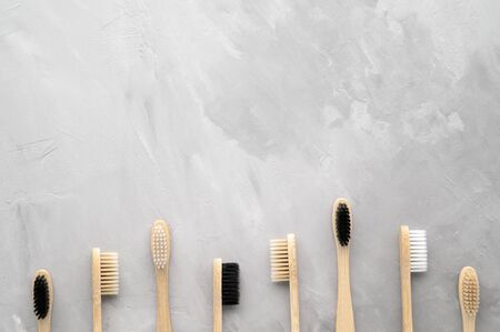 Zero waste and no plastic concept. Group of eco natural bamboo toothbrushes on a gray concrete...