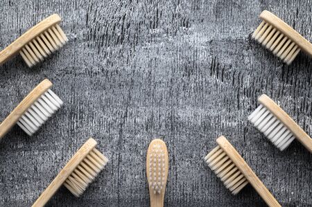 Zero waste and no plastic concept. Group of eco natural bamboo toothbrushes on a gray wooden...
