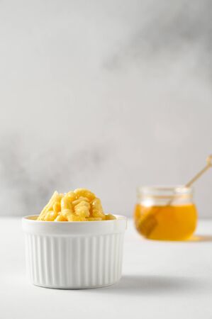 National food cuisine of the Middle East. White ramekin with chak chak and honey in a jar on a white table. Vertical orientation, copy space.の写真素材