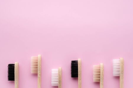 Zero waste and no plastic concept. Group of eco natural bamboo toothbrushes on a pastel pink surface. Flat lay, copy space, horizontal orientation. Layout natural organic hygiene products.の写真素材