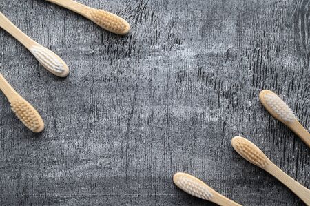 Zero waste and no plastic concept. Group of eco natural bamboo toothbrushes on a gray wooden background. From above, copy space, horizontal orientation. Layout natural organic hygiene products.の写真素材